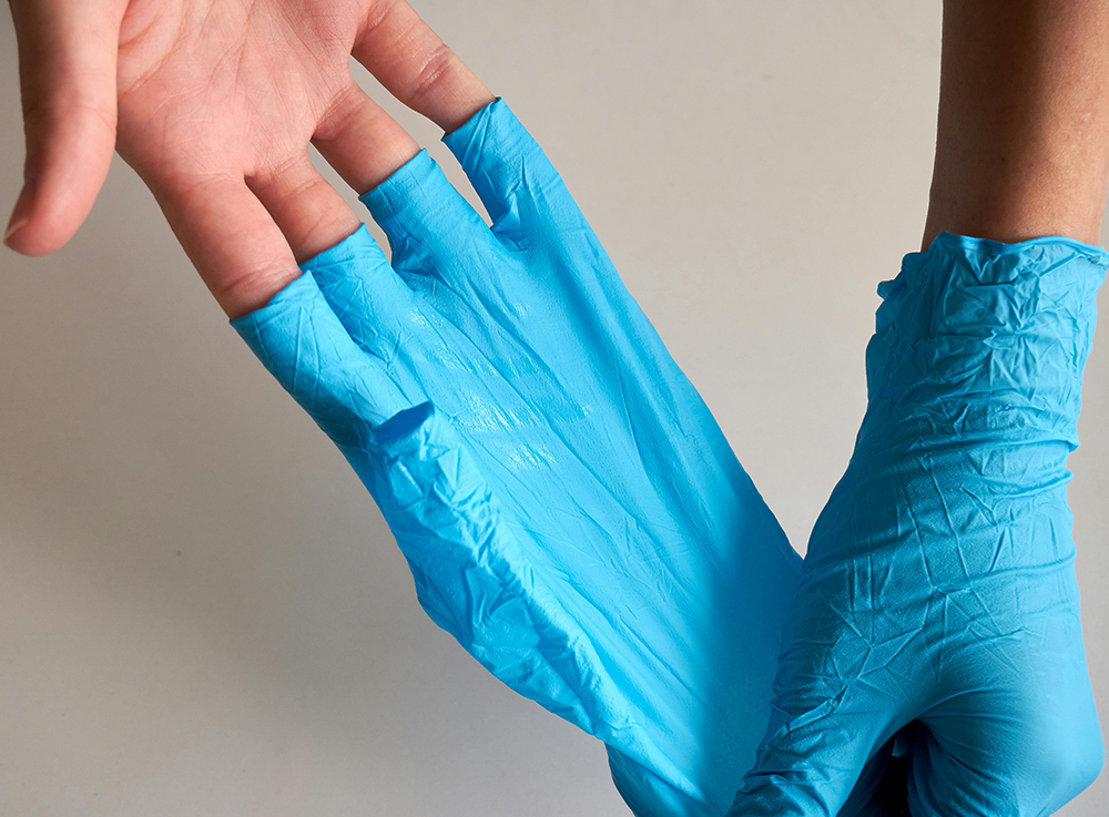 A Person Removing Rubber Gloves